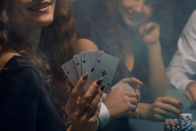 Woman holding winning poker hand at casino table representing no verification online casinos for real money players
