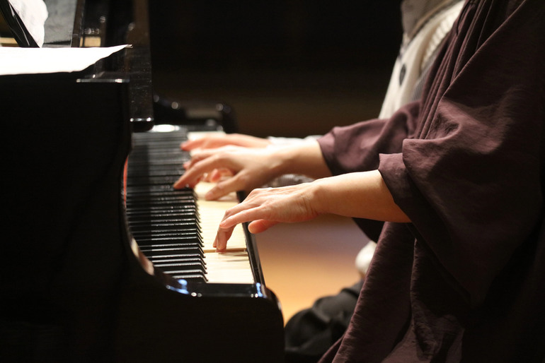 Adult piano student practicing on a grand piano, inspired by the vibrant live music scene in New York City